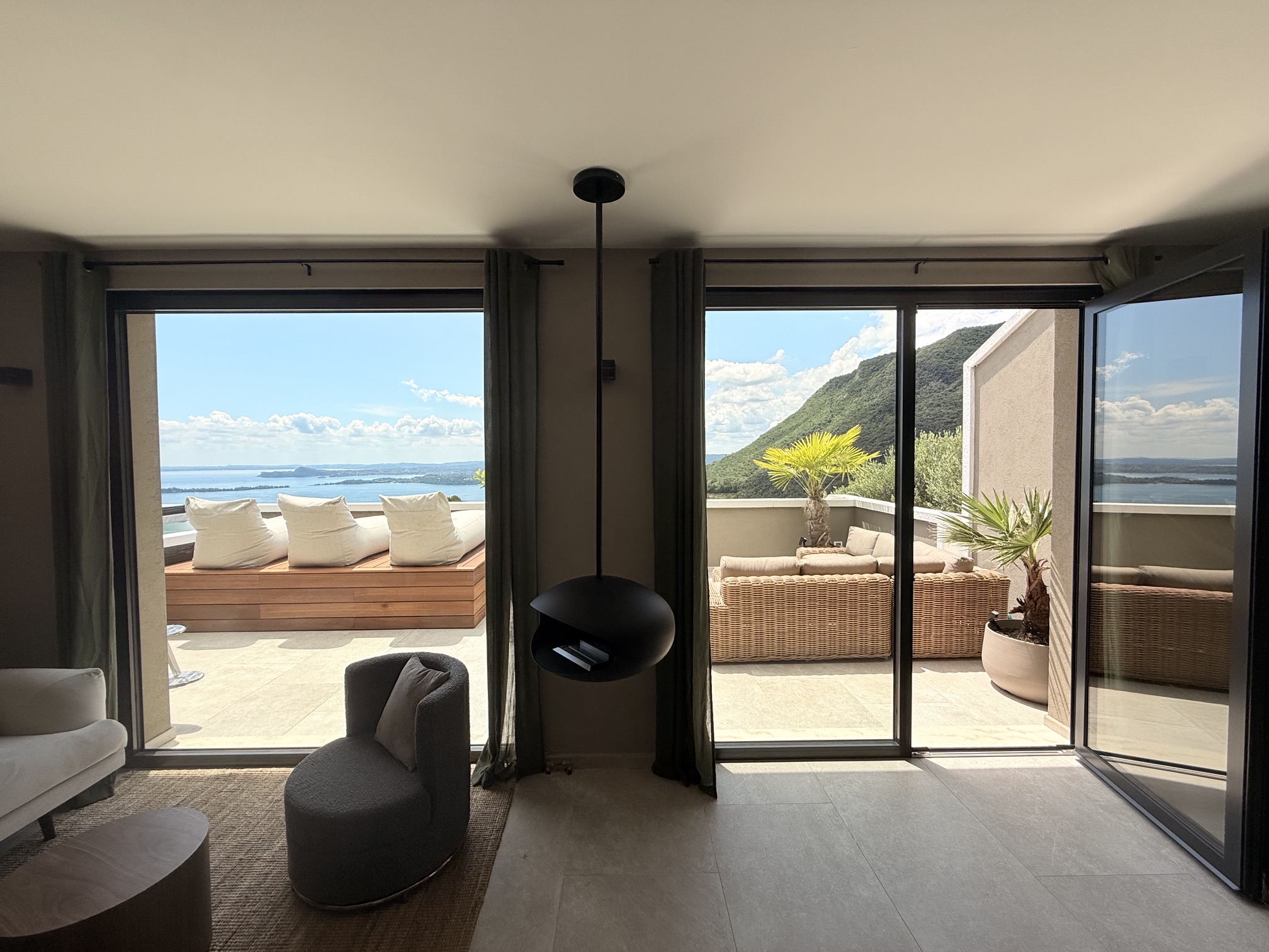Penthouse Sky Spa · M4 · Wohnzimmer mit schwarzem Hängekamin und Blick auf die Terrasse