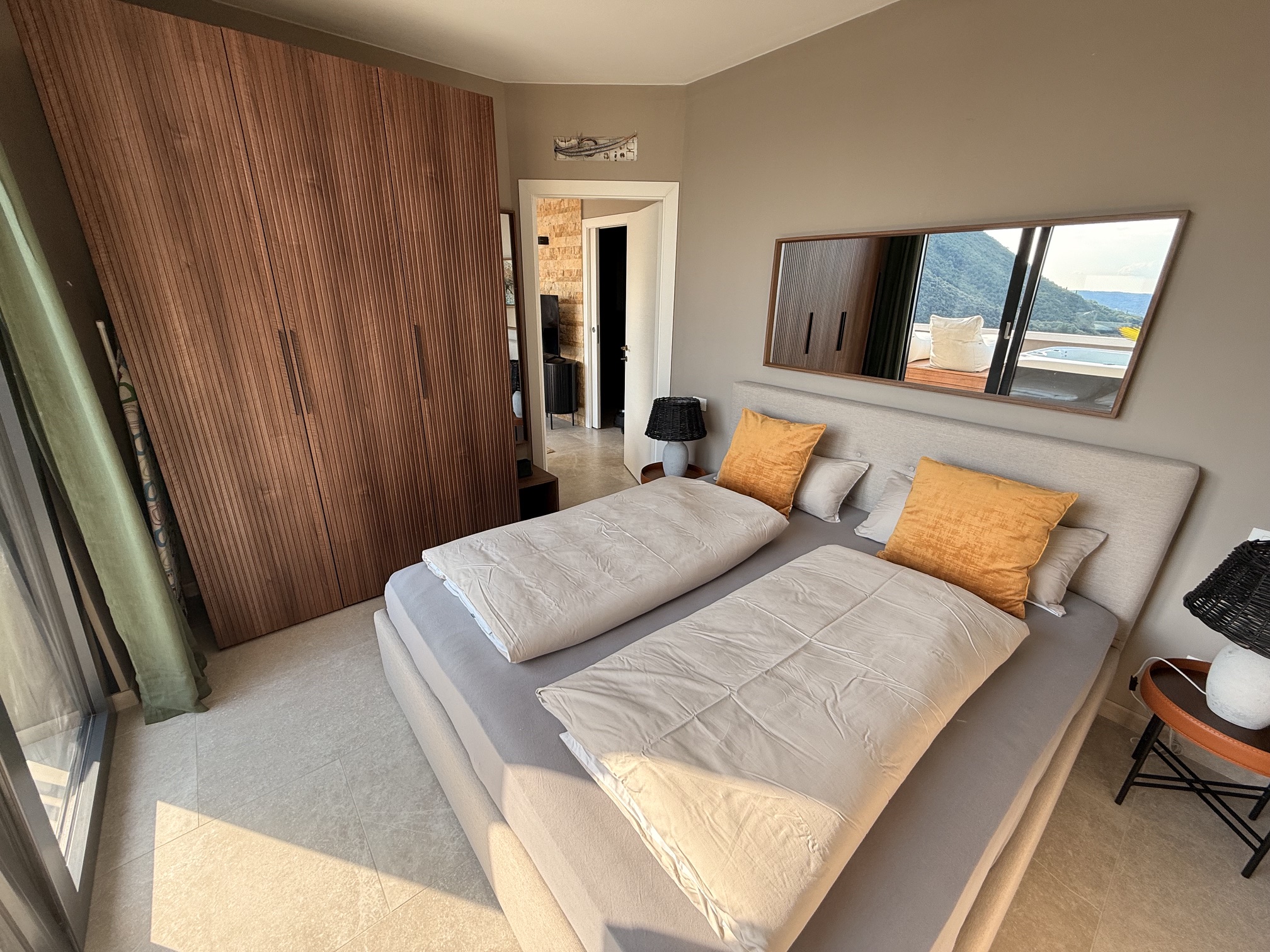 Penthouse Sky Spa · M4 · Master-Schlafzimmer mit orangenen Akzentkissen und Holzschrank